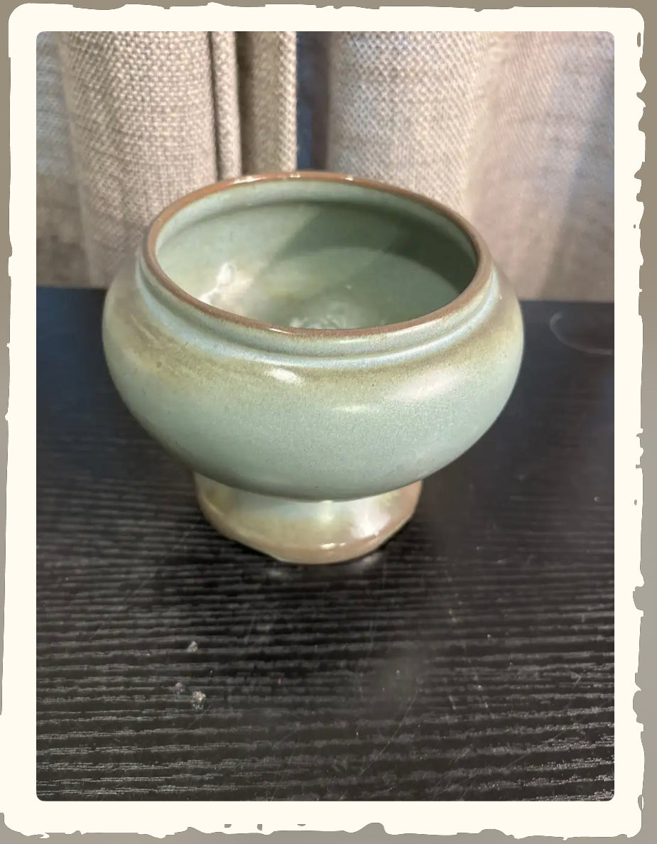 Vintage Frankoma Prairie Green footed bowl with smooth celadon glaze on dark wood surface