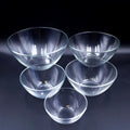 Set of 5 clear glass cat bowls in graduated sizes arranged on dark background